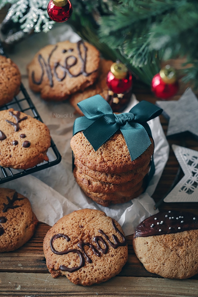 Biscuits de Noël à la cannelle avec décorations au chocolat et présentés en cadeau avec un ruban – idée gourmande pour les fêtes.