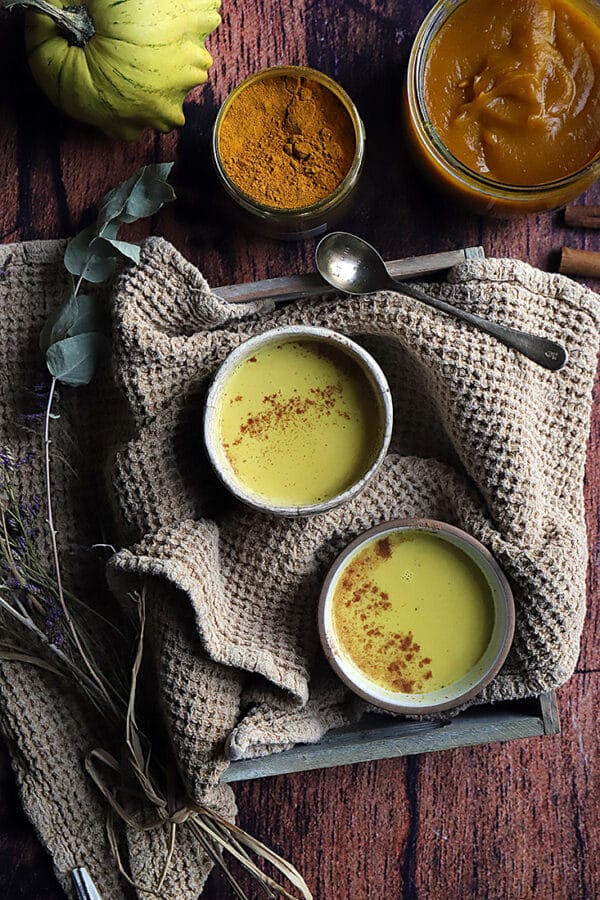 recette de Golden latte à la courge servi dans une tasse avec des épices et de la purée de courge.