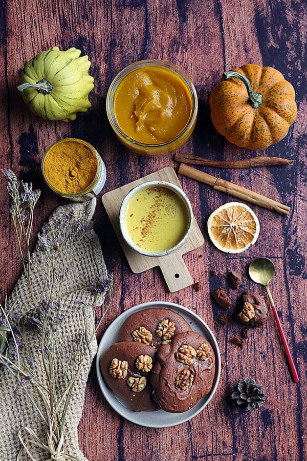 Sélection de gourmandises d’automne avec épices, purée de courge, golden latte, et biscuits aux noix.